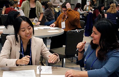 Young femail attendees talkking during roundtable discussions.